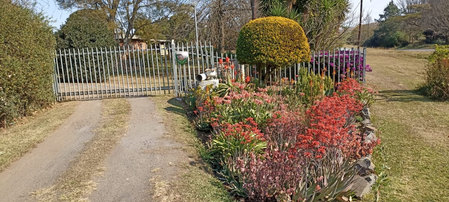 Entrance gate to Ghyllwood Farm with flower beds