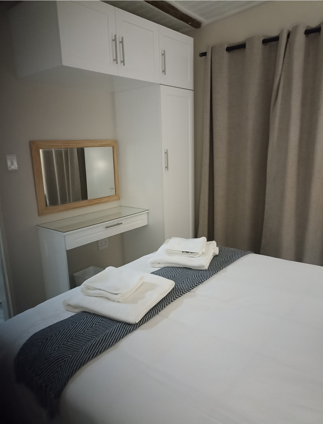 Main bedroom dressing area with fresh linen